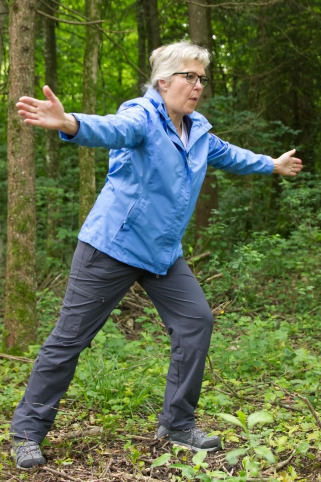 Ältere Frau macht Gymnastik im Wald