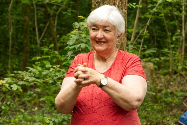 Ältere Frau macht Gymnastik im Wald